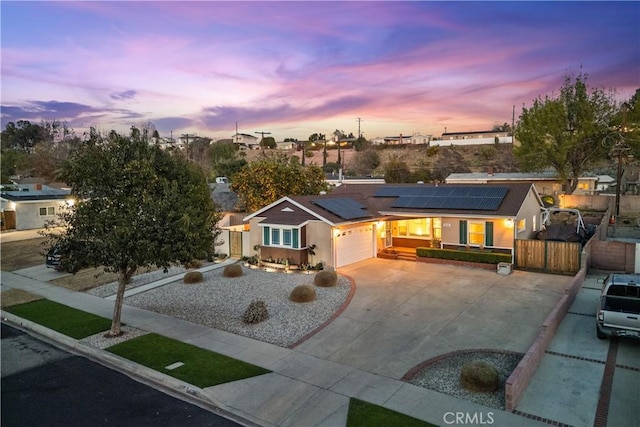 view of front of home featuring a garage and solar panels