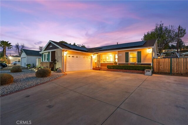 single story home featuring a garage and solar panels