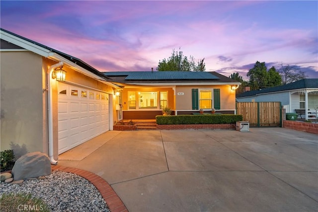 ranch-style house with a garage and solar panels