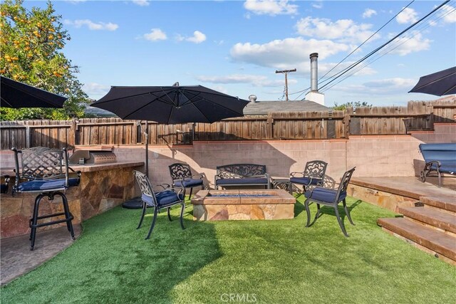 view of yard featuring a bar, an outdoor fire pit, and a patio