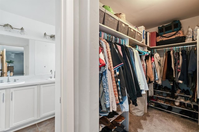 spacious closet with sink and carpet flooring