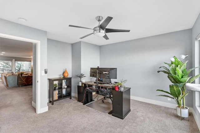 carpeted office space with ceiling fan