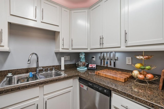 kitchen with white cabinetry, sink, stainless steel dishwasher, and dark stone counters