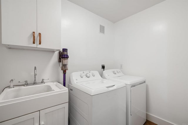 laundry area featuring a sink, cabinet space, visible vents, and washer and dryer