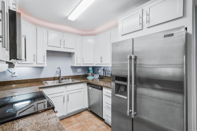 kitchen with white cabinets, light tile patterned floors, stainless steel appliances, and a sink