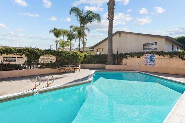 pool with fence and a patio