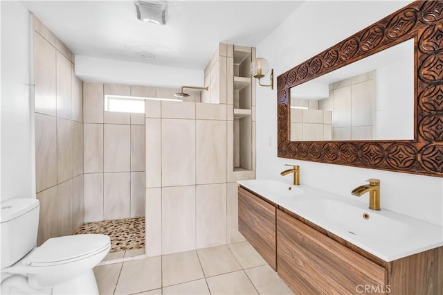 bathroom with vanity, tile patterned floors, toilet, and tiled shower