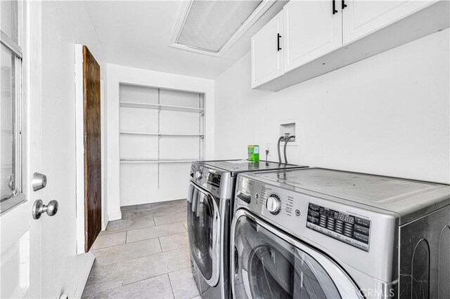 clothes washing area with independent washer and dryer, light tile patterned floors, and cabinets