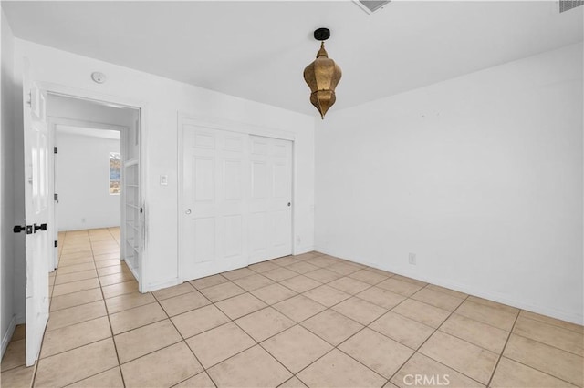 unfurnished bedroom featuring light tile patterned floors and a closet