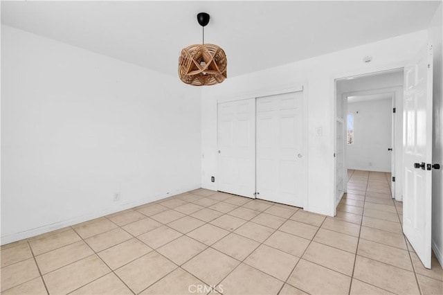 unfurnished bedroom with a closet and light tile patterned floors