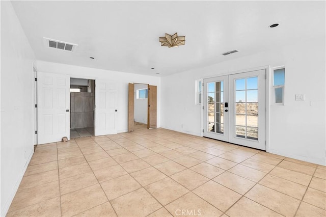 spare room with light tile patterned floors and french doors