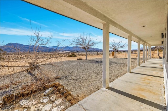 view of yard featuring a mountain view, a patio area, and a rural view