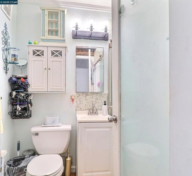 bathroom featuring vanity, decorative backsplash, and toilet