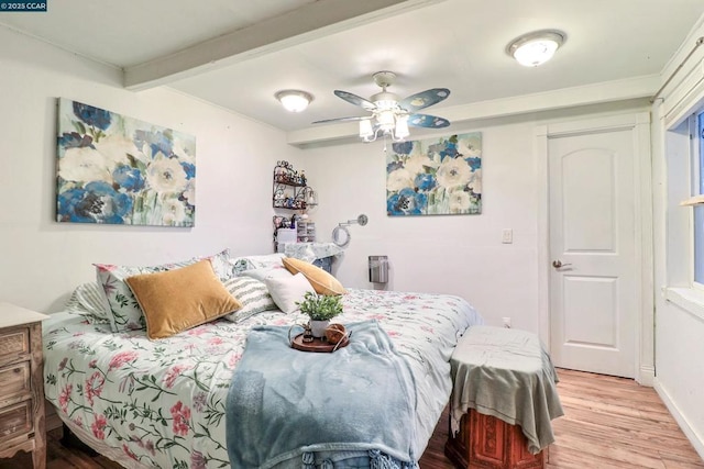 bedroom with beamed ceiling, ceiling fan, and light hardwood / wood-style floors