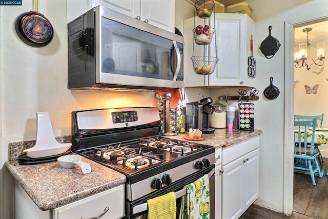 kitchen featuring white cabinetry, stainless steel appliances, dark hardwood / wood-style floors, and an inviting chandelier