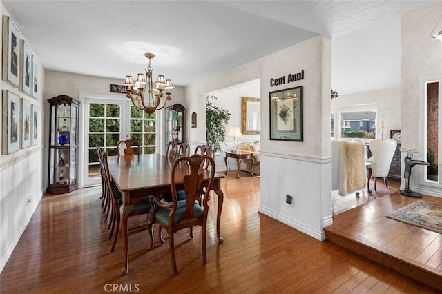 dining space featuring dark wood-type flooring and a notable chandelier