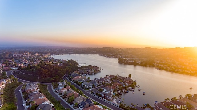 aerial view at dusk featuring a water view