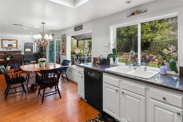 kitchen with pendant lighting, dishwasher, sink, white cabinets, and light wood-type flooring