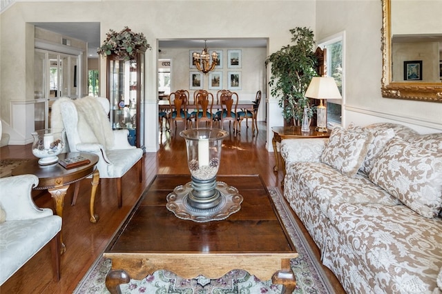 living room with dark hardwood / wood-style flooring and a chandelier