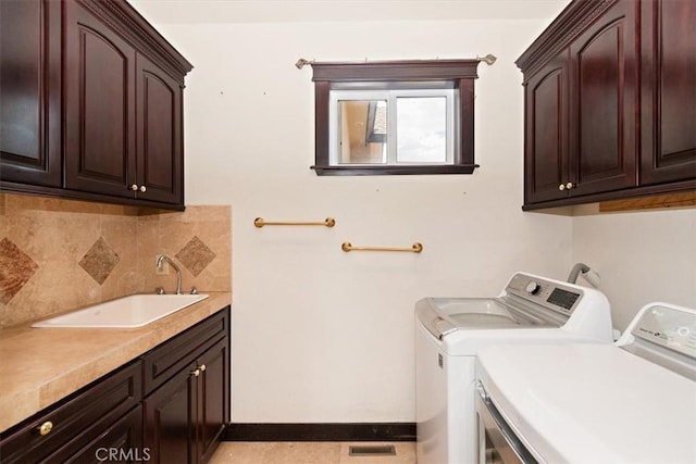 washroom featuring cabinets, sink, and washing machine and dryer