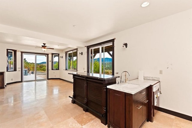 kitchen with ceiling fan, sink, and dark brown cabinets