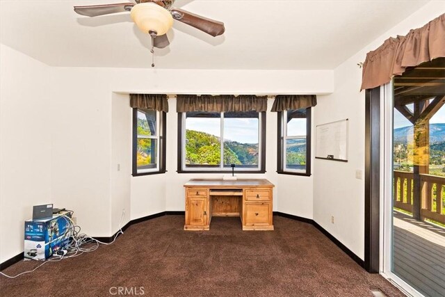 unfurnished office with ceiling fan and dark carpet