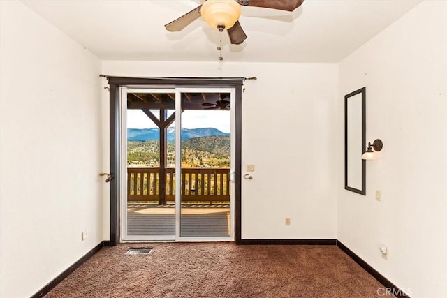 empty room featuring ceiling fan and dark carpet