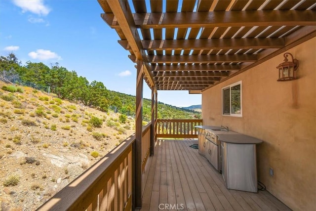 wooden deck with sink and a pergola