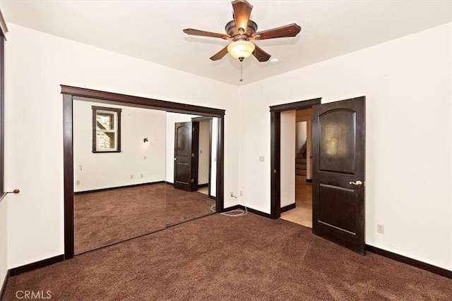 unfurnished bedroom featuring ceiling fan and dark colored carpet