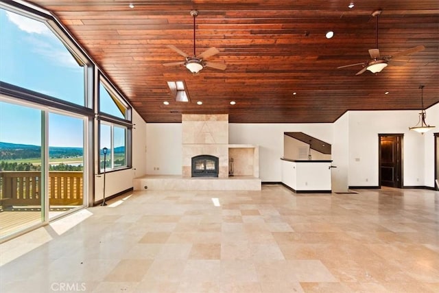 unfurnished living room with a tile fireplace, wood ceiling, and ceiling fan