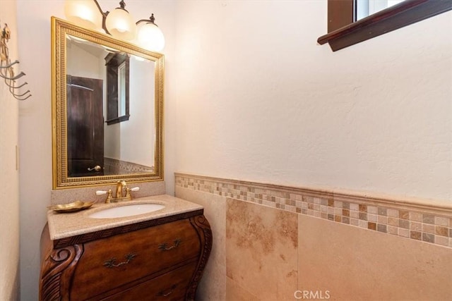 bathroom with vanity and tile walls