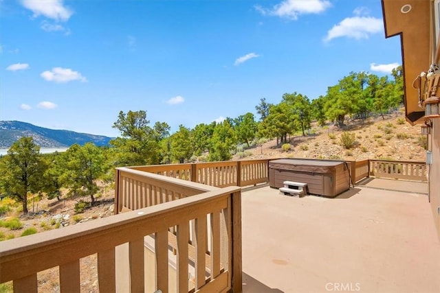 wooden deck featuring a hot tub and a mountain view