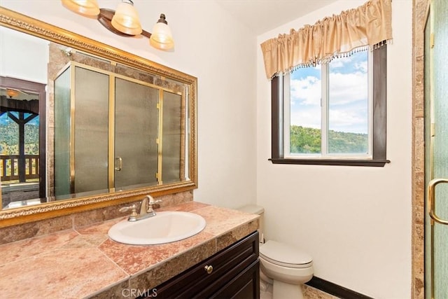 bathroom with vanity, toilet, and a shower with door