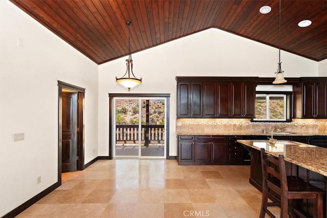 bar with light stone countertops, pendant lighting, backsplash, and dark brown cabinetry