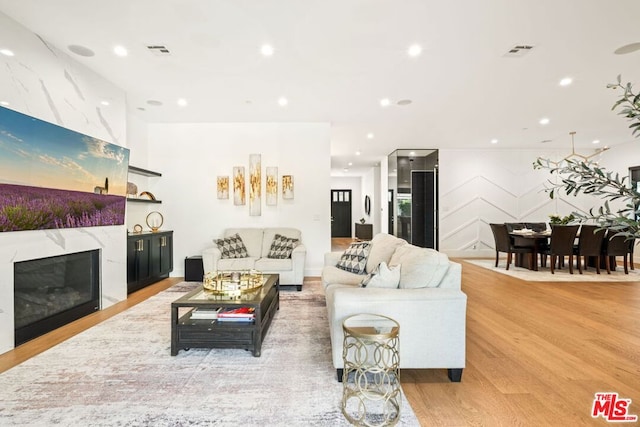 living room featuring a fireplace and light wood-type flooring