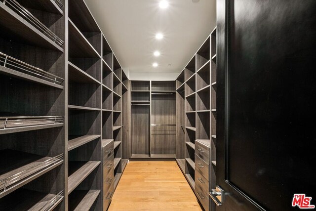 spacious closet with light hardwood / wood-style flooring