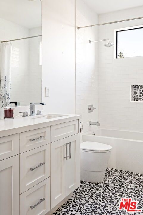 full bathroom featuring vanity, toilet, tile patterned flooring, and shower / bath combo