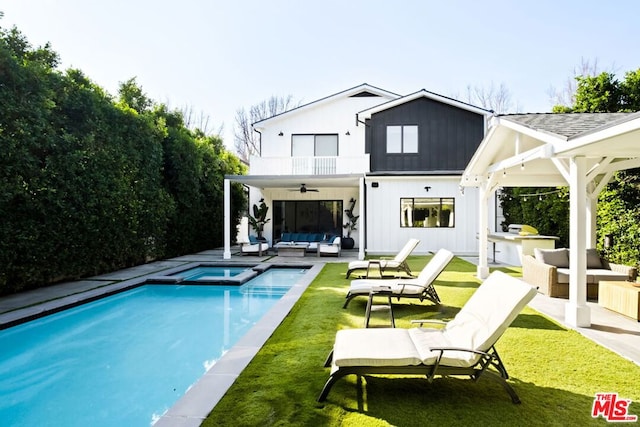 back of property featuring ceiling fan, a yard, a patio, an outdoor living space, and a balcony