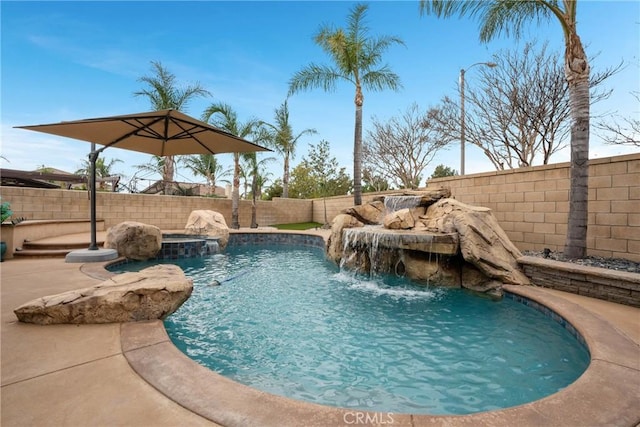 view of swimming pool featuring pool water feature and an in ground hot tub