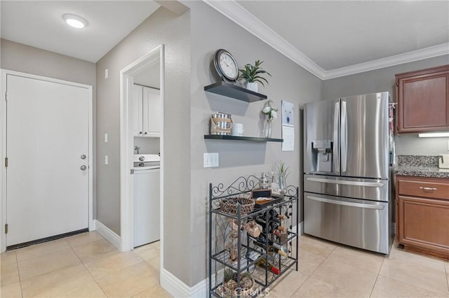 kitchen with stainless steel fridge with ice dispenser, light tile patterned floors, ornamental molding, and washer / clothes dryer