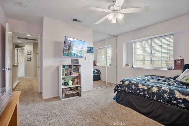 bedroom featuring light carpet, a closet, and ceiling fan