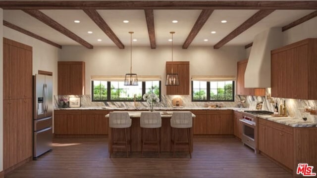 kitchen with hanging light fixtures, backsplash, stainless steel appliances, light stone countertops, and a center island with sink