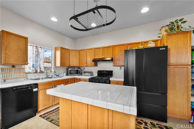 kitchen featuring sink, a center island, tile counters, light tile patterned floors, and black appliances