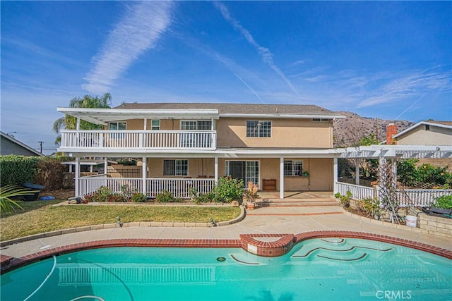 rear view of property with a fenced in pool, a pergola, a mountain view, and a patio area