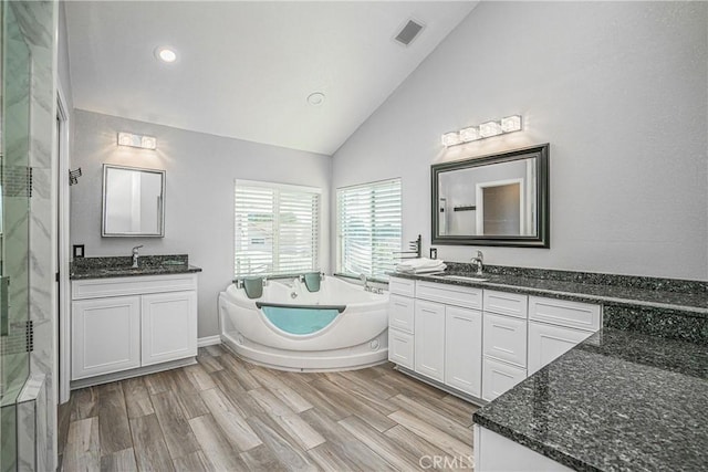 bathroom with lofted ceiling, vanity, separate shower and tub, and wood-type flooring