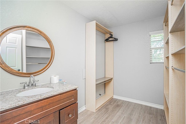 bathroom with vanity, wood-type flooring, and a textured ceiling