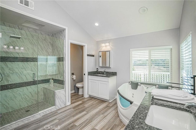 full bathroom featuring vanity, wood-type flooring, vaulted ceiling, independent shower and bath, and toilet