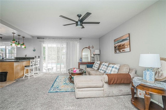 living room featuring sink, ceiling fan, and carpet