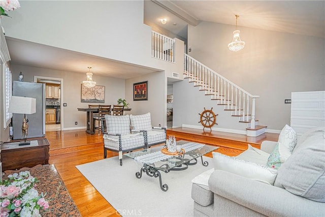 living room featuring hardwood / wood-style flooring, high vaulted ceiling, and beamed ceiling