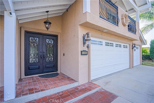 entrance to property with a garage, french doors, and a balcony